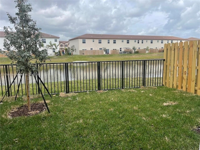 view of yard featuring a fenced backyard and a water view