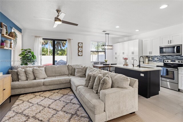 4859 NW 55th Pl, Tamarac, FL 33319 - living area with a ceiling fan, recessed lighting, a textured ceiling, and a chandelier