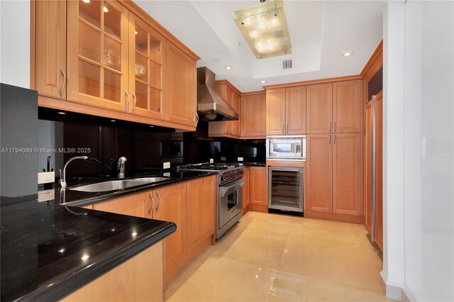 17875 Collins Ave Unit 905, Sunny Isles Beach, FL 33160 - kitchen with wall chimney range hood, appliances with stainless steel finishes, a sink, wine cooler, and glass insert cabinets