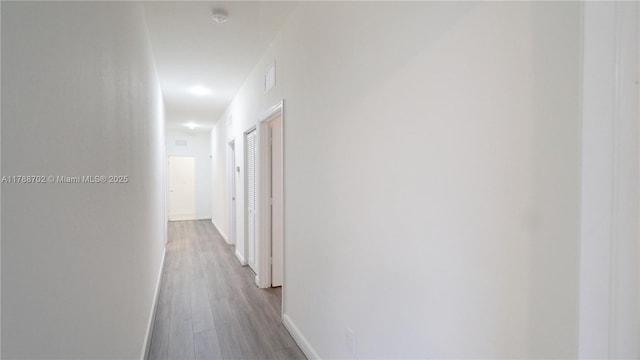 hall featuring baseboards and wood finished floors