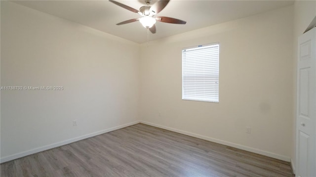 empty room with baseboards, ceiling fan, and wood finished floors