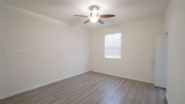 spare room with baseboards, ceiling fan, and wood finished floors
