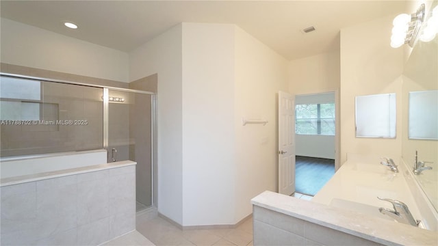 full bathroom with visible vents, a shower stall, a sink, and tile patterned flooring