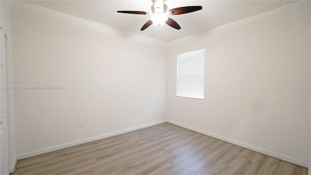 empty room featuring baseboards, a ceiling fan, and light wood finished floors