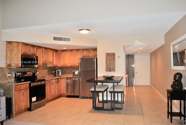 49 Deer Creek Rd Unit E105, Deerfield Beach, FL 33442 - kitchen featuring stainless steel appliances, visible vents, light tile patterned floors, and tasteful backsplash