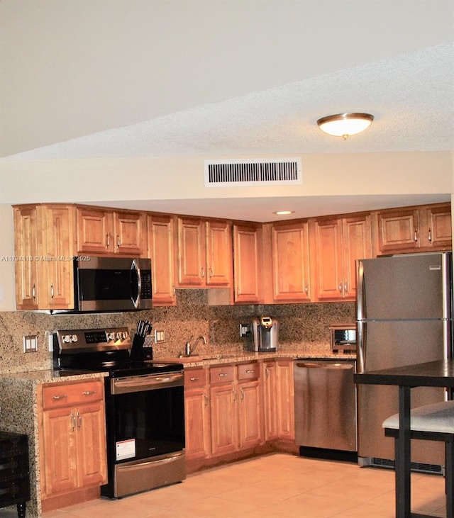 49 Deer Creek Rd Unit E105, Deerfield Beach, FL 33442 - kitchen featuring backsplash, appliances with stainless steel finishes, light stone counters, and visible vents