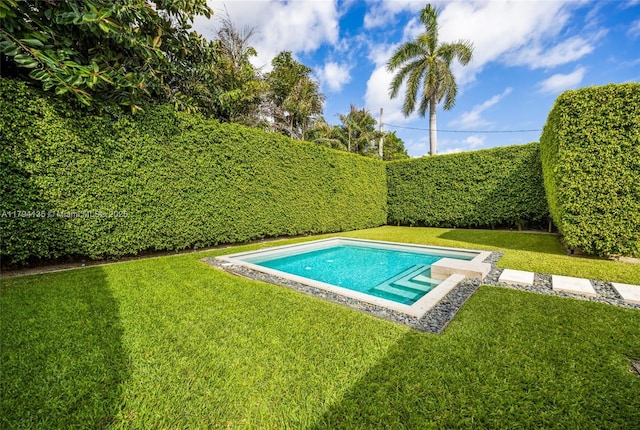 view of pool with a lawn and a fenced backyard