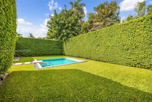view of swimming pool featuring a lawn, a fenced in pool, and a fenced backyard