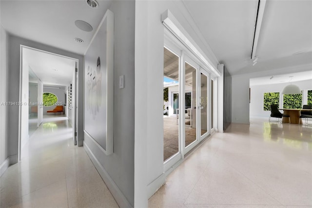 hallway featuring baseboards and speckled floor