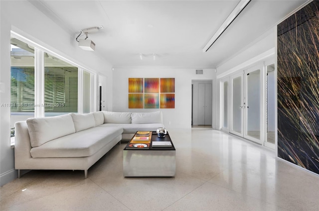 living area featuring visible vents and speckled floor