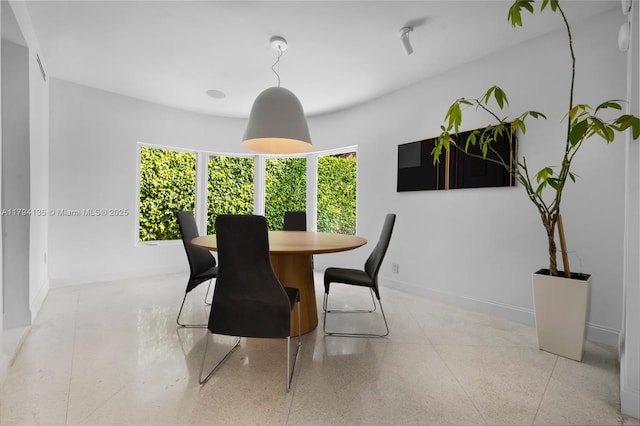 dining area featuring baseboards and speckled floor