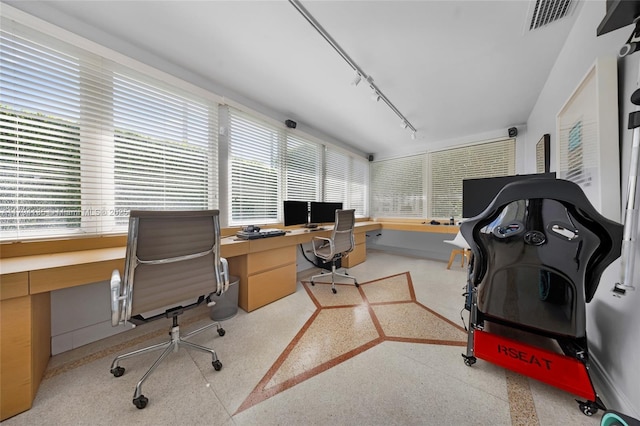 home office with track lighting, a wealth of natural light, and visible vents