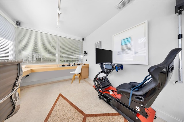 exercise room with baseboards, plenty of natural light, rail lighting, and visible vents