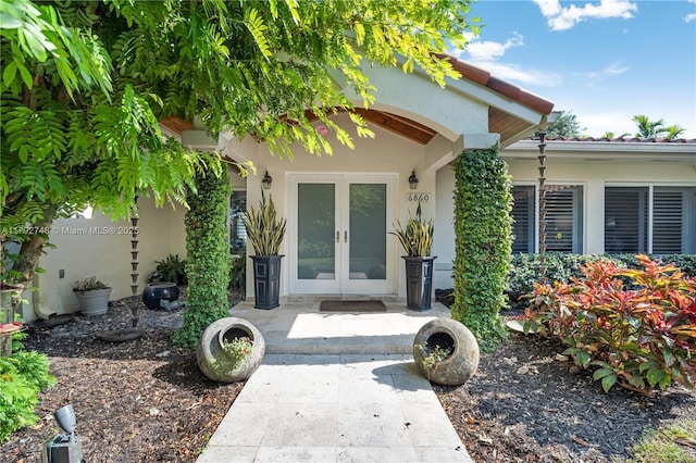 entrance to property featuring french doors and stucco siding
