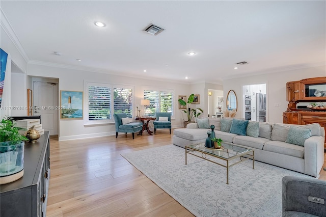 living area featuring light wood-style flooring, recessed lighting, baseboards, visible vents, and ornamental molding