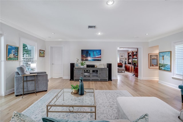 living room with visible vents, crown molding, wood finished floors, and a healthy amount of sunlight