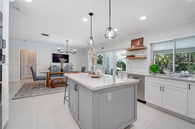 kitchen featuring crown molding, a center island, a sink, and dishwasher