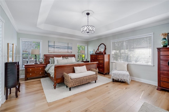 bedroom featuring light wood-type flooring, baseboards, a tray ceiling, and an inviting chandelier
