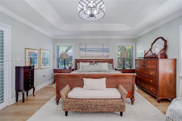 bedroom with baseboards, a notable chandelier, light wood-style flooring, and a raised ceiling