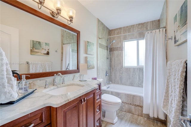 full bath with vanity, toilet, and tiled shower / bath combo