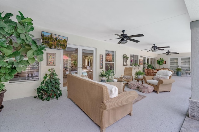 living area with ceiling fan and french doors