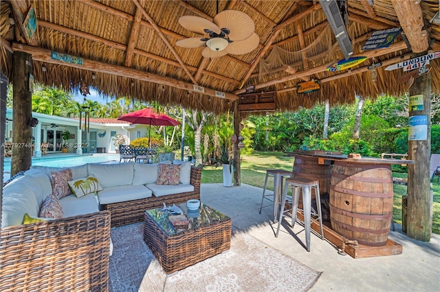 view of patio with an outdoor hangout area, a ceiling fan, a gazebo, and a bar
