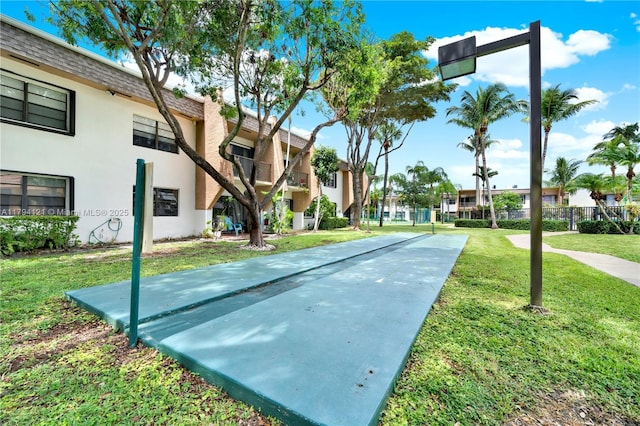 view of property's community featuring a lawn, shuffleboard, and a residential view