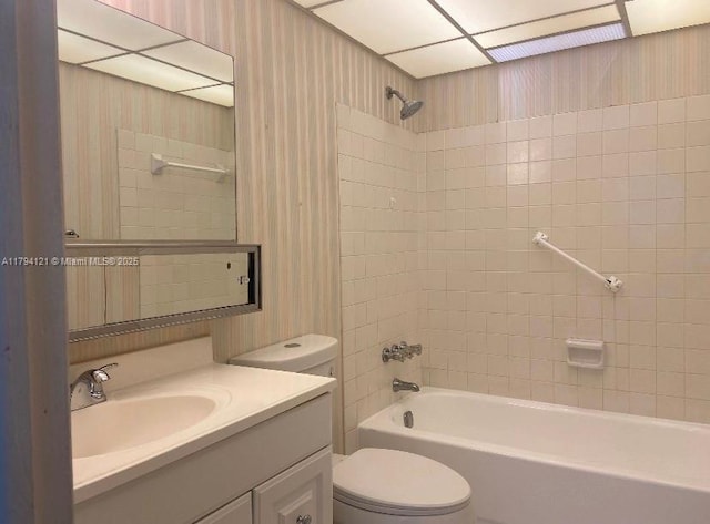 bathroom featuring bathing tub / shower combination, wallpapered walls, vanity, and toilet