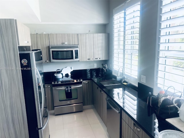 450 N Federal Hwy Unit 102, Boynton Beach, FL 33435 - kitchen with stainless steel appliances, a sink, dark countertops, light tile patterned floors, and plenty of natural light