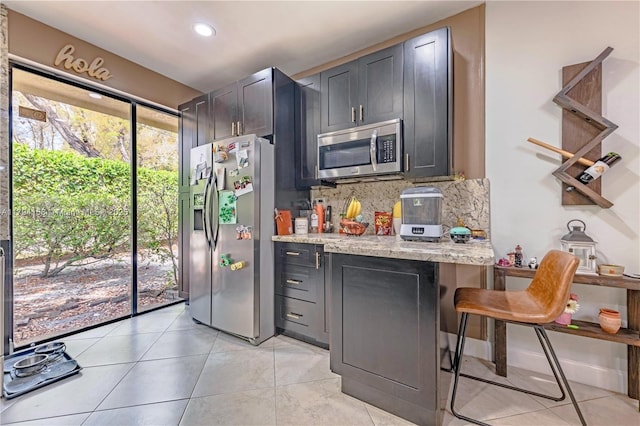 8097 Royal Palm Cir, Tamarac, FL 33321 - kitchen with light stone countertops, appliances with stainless steel finishes, a kitchen breakfast bar, recessed lighting, and backsplash