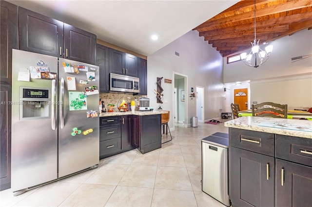 8097 Royal Palm Cir, Tamarac, FL 33321 - kitchen with light stone countertops, tasteful backsplash, stainless steel appliances, light tile patterned floors, and a towering ceiling