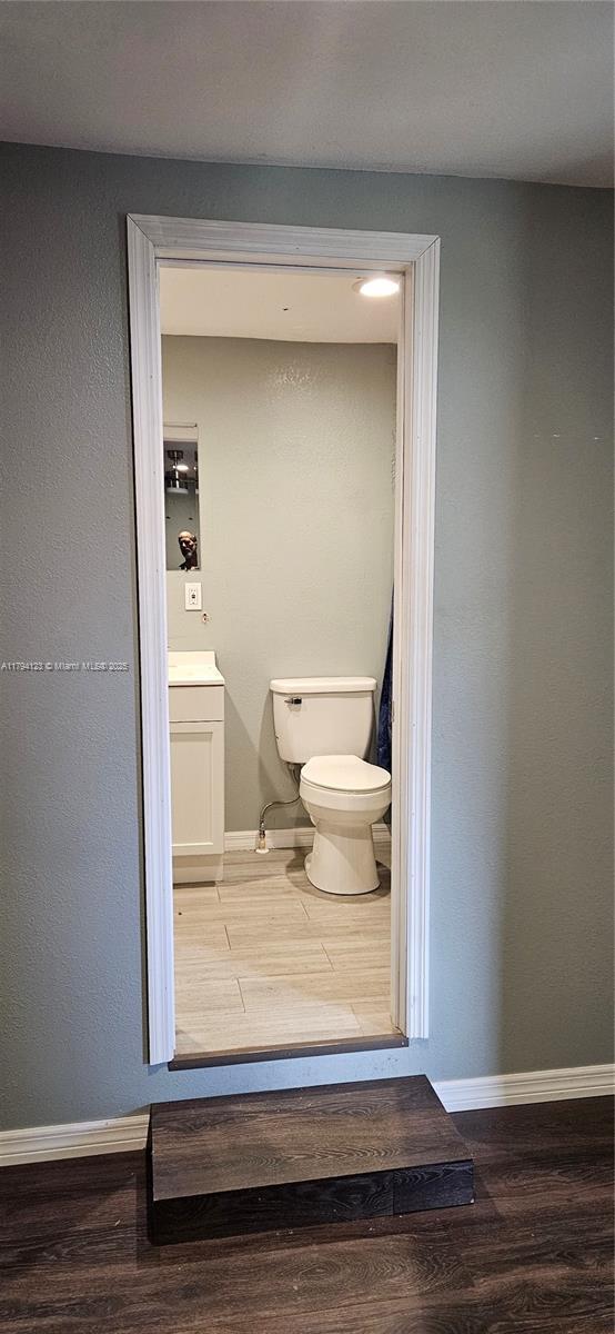 3100-3112 Sanders Rd, Davenport, FL 33837 - bathroom featuring toilet, baseboards, and wood finished floors
