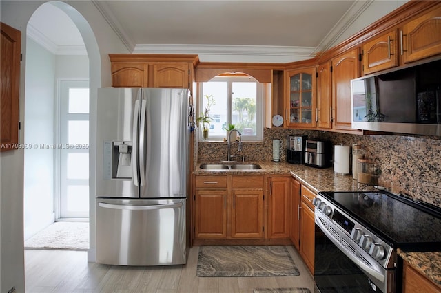 kitchen with a sink, appliances with stainless steel finishes, and brown cabinets