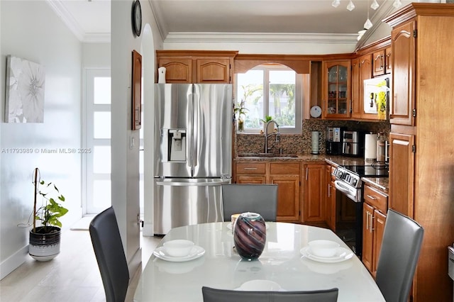 kitchen featuring a sink, appliances with stainless steel finishes, and brown cabinetry