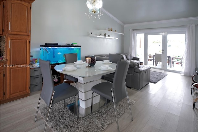 dining room featuring light wood-style floors, ornamental molding, and lofted ceiling