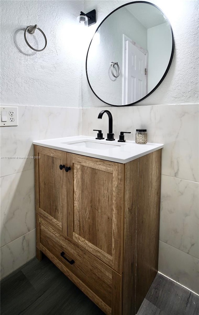bathroom featuring vanity and tile walls