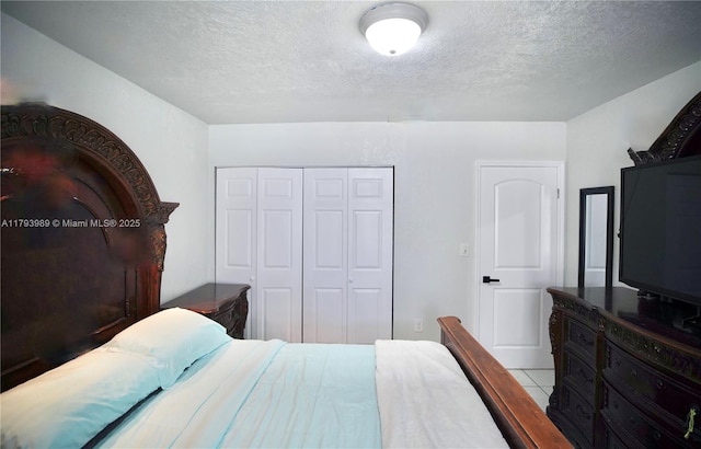 tiled bedroom with a closet and a textured ceiling