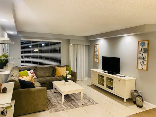 310 Golden Isles Dr Unit 109, Hallandale Beach, FL 33009 - living room featuring light tile patterned flooring, a textured ceiling, and baseboards