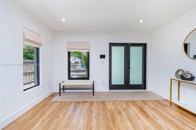 entryway with baseboards, wood finished floors, a wealth of natural light, and french doors