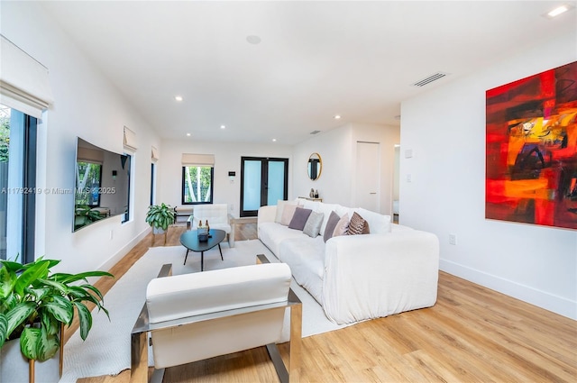 living room with baseboards, recessed lighting, wood finished floors, and visible vents