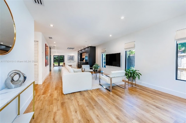 living room with recessed lighting, baseboards, visible vents, and light wood-style flooring