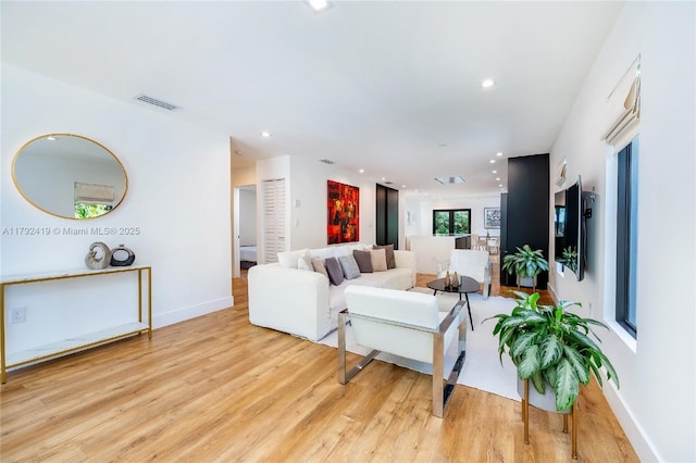 living room with visible vents, recessed lighting, light wood-style flooring, and baseboards
