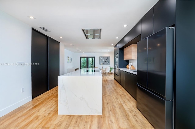 kitchen with dark cabinetry, modern cabinets, black appliances, and visible vents
