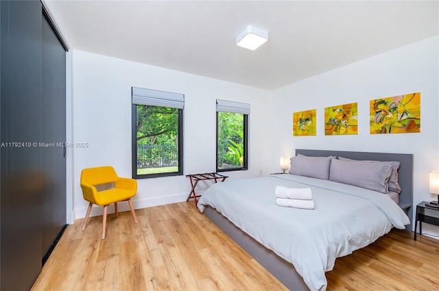 bedroom with baseboards and light wood-type flooring