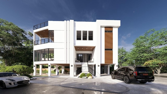 view of property featuring stairs and uncovered parking
