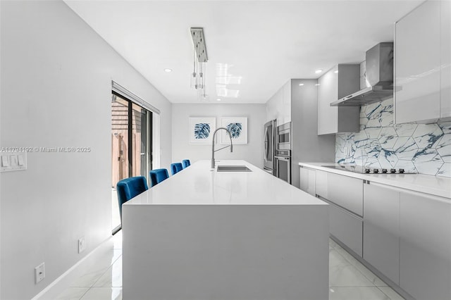 kitchen featuring appliances with stainless steel finishes, a sink, wall chimney exhaust hood, decorative backsplash, and modern cabinets