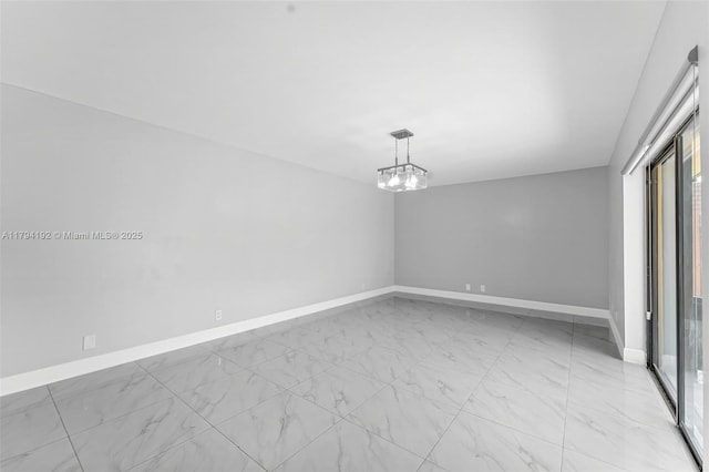 unfurnished room featuring baseboards, marble finish floor, and a notable chandelier