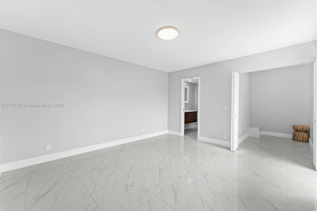 unfurnished bedroom with baseboards and marble finish floor