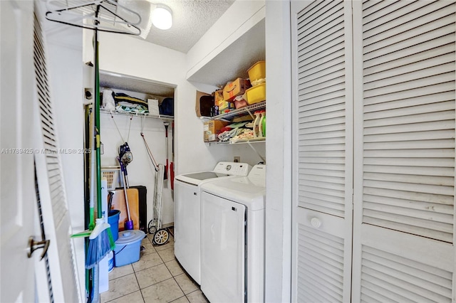 laundry area featuring light tile patterned floors, a textured ceiling, laundry area, and independent washer and dryer