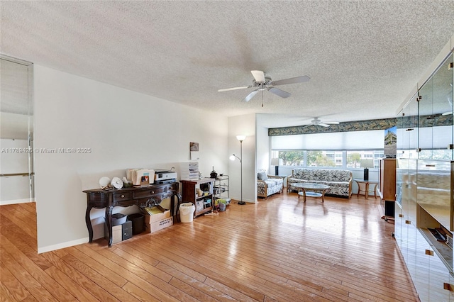 bedroom with wood-type flooring, a textured ceiling, and baseboards